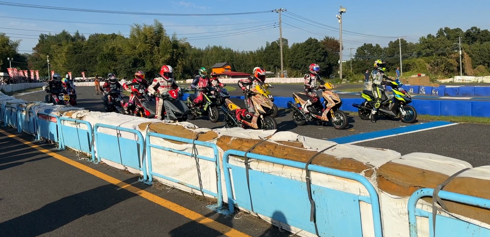 サーキット秋ヶ瀬のグリッドに整列したS-1GPのスクーターとライダー